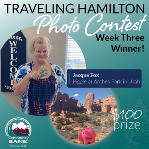 Jacque fox with her image of Hamilton the piggy bank posed in front of Arches Park in Utah.